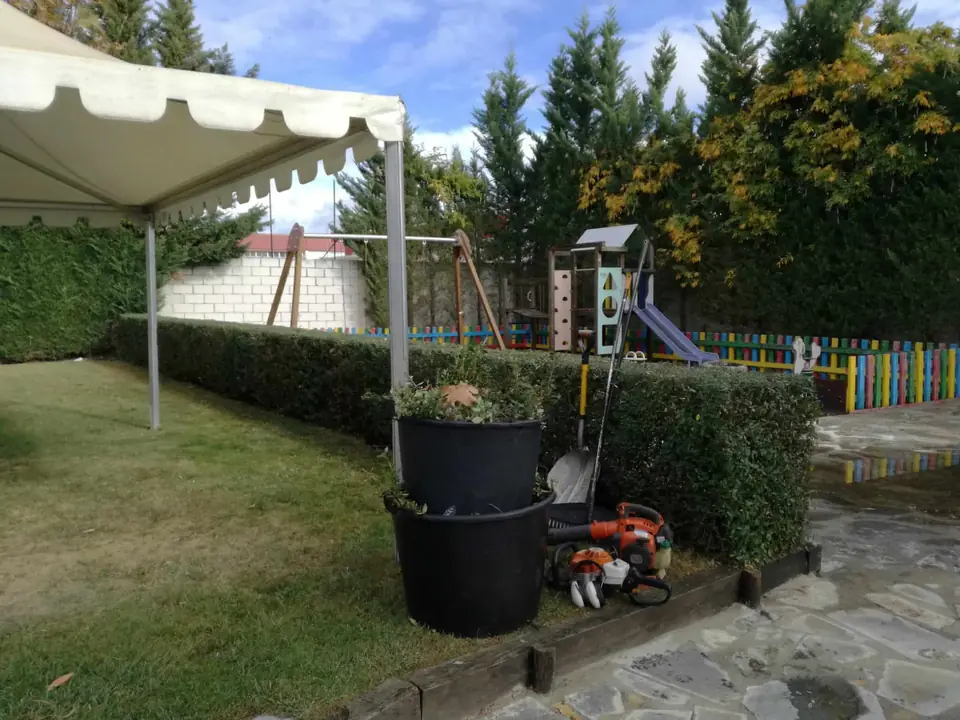 Seto recortado alrededor de un parque infantil comunitario